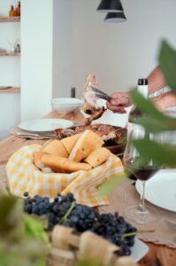 Plato de cordero lechal asado con uvas y vino tinto durante la vendimia en Ribera del Duero